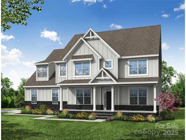 Beautiful two-story home featuring white siding, covered porch, meticulous landscaping, and a well-manicured lawn at Tbd Boomer Ct # 7, Statesville, NC 28677