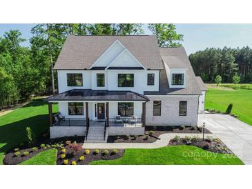 Charming two-story home with white siding, black windows, covered porch and professionally landscaped front yard at Tbd Boomer Ct # 7, Statesville, NC 28677