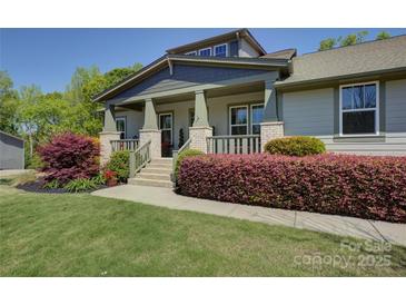 Charming home featuring a welcoming front porch, well-manicured landscaping, and mature trees at 1306 Kings Bottom Dr, Fort Mill, SC 29715