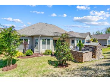 A beautiful outdoor living space with lush lawn, brick fireplace, and seating area at 17315 Langston Dr, Charlotte, NC 28278
