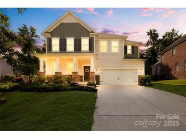 Charming two-story home with a well-manicured lawn, inviting front porch, and a two-car garage at 17413 Caddy Ct, Charlotte, NC 28278