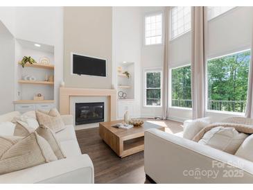 Bright living room features large windows, fireplace, hardwood floors, and modern décor at 200 Royalton Pl, Huntersville, NC 28078