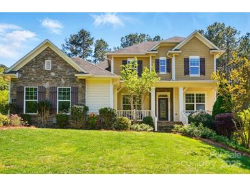 Charming two-story home with a stone facade, landscaped yard, shutters, and inviting front porch at 404 Brookridge Dr, Mount Holly, NC 28120