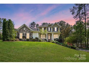 Charming two-story home with a well-manicured lawn and a stone facade at 404 Brookridge Dr, Mount Holly, NC 28120