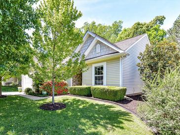 Charming home with a well-manicured lawn, mature trees, and colorful landscaping at 4143 Tullock Creek Dr, Charlotte, NC 28269