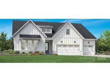 Charming two-story home features white siding, a two-car garage, and a well-manicured front yard at 5040 Mint Harbor Way # 0404, Charlotte, NC 28269