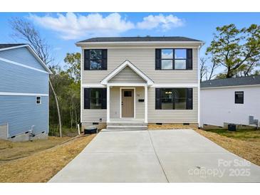 Charming two-story home showcasing neutral siding, black shutters, and a well-manicured front yard at 74 Snyder Ne Ct, Concord, NC 28025