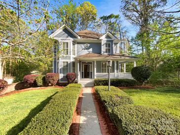 Charming two-story home with blue siding, a welcoming front porch, and meticulously manicured landscaping at 845 Creek Bluff Rd, Rock Hill, SC 29732