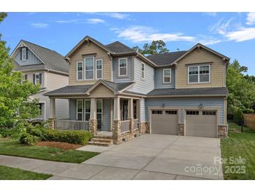 Inviting two-story home with a covered front porch and two-car garage, perfect for a growing Gathering at 10423 Drake Hill Dr, Huntersville, NC 28078