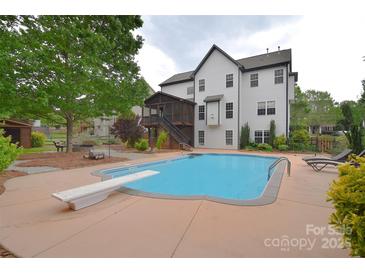 Inviting pool with diving board alongside a spacious backyard and screened in porch at 1811 Robbins Meadows Dr, Waxhaw, NC 28173