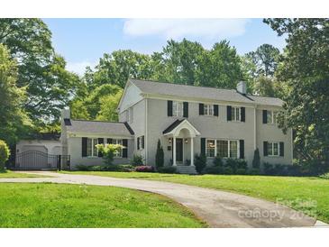 Charming two-story home with mature landscaping and a curved driveway on a lush green lawn at 1927 S Wendover Rd, Charlotte, NC 28211