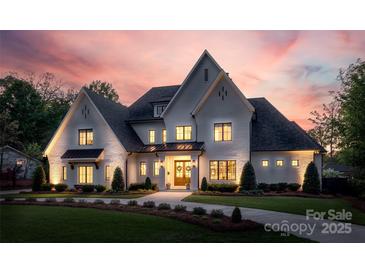 Stunning white brick home with manicured lawn, welcoming entrance, and a lovely dusk sky at 1976 Ferncliff Rd, Charlotte, NC 28211