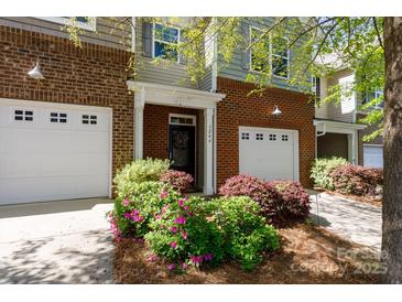 Charming townhome exterior featuring a brick facade, attached garage, and beautiful landscaping with flowering bushes at 3246 Yarmouth Ln, Gastonia, NC 28056