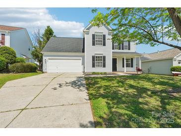 Charming two-story home with a well-maintained lawn, an attached garage, and classic curb appeal at 3335 Hawick Commons Dr, Concord, NC 28027