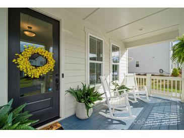 Charming covered front porch with rocking chairs, plants, and a welcoming wreath on the front door at 4012 Spring Cove Way, Belmont, NC 28012