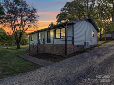 Charming single-story home featuring white siding, brick foundation, and a covered porch with black railings at 4903 Walt Gay Rd, Monroe, NC 28112