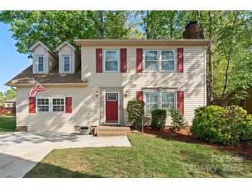 Charming two-story home features dormer windows, red shutters, brick steps, and a well-manicured lawn at 7220 Spring Morning Ln, Charlotte, NC 28227
