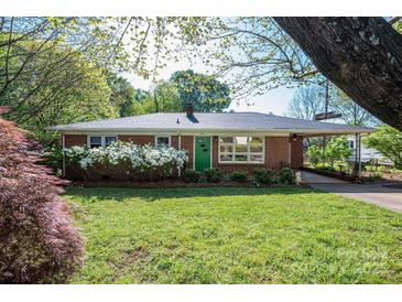 Charming brick home with a well-manicured lawn, vibrant azaleas, and a welcoming green front door at 821 Mark St, Belmont, NC 28012