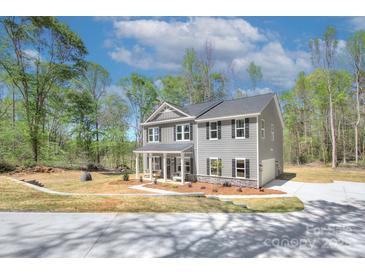 Beautiful two-story home with gray siding, black shutters, and a well-manicured front yard at 1033 Harrogate Dr, Bessemer City, NC 28016
