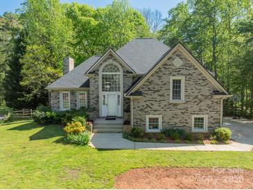 Charming home features a brick facade, arched window above entry, and lush landscaping at 108 Tall Oak Dr, Mooresville, NC 28117