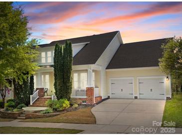 Charming two-story home with a two-car garage and lovely landscaped front yard at sunset at 12614 Robert Walker Dr, Davidson, NC 28036