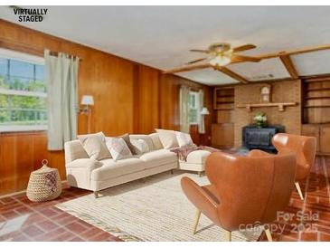 Bright living room features neutral walls and cream colored seating and light colored rug and ceiling fan at 1331 Mccorkle Rd, Charlotte, NC 28214