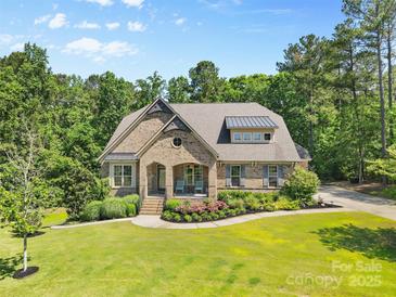 Beautiful brick home featuring well-manicured landscaping and a welcoming front porch at 15210 Pavilion Valley Cir, Huntersville, NC 28078