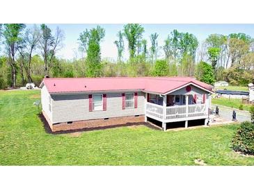 Charming single-story home featuring red roof and cozy front porch in a serene, wooded setting at 161 Hickory Nut Dr, Statesville, NC 28677