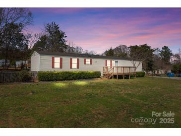 Charming single-story home featuring red shutters, a cozy front porch, and a spacious, green front yard at 189 Woodwinds Dr, Mooresville, NC 28115