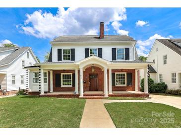 Charming two-story home with red brick and a manicured lawn showcasing its classic design at 2015 Dilworth E Rd, Charlotte, NC 28203