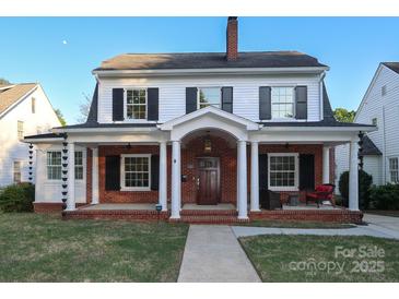Charming two-story home with brick facade, inviting front porch with white columns and classic black shutters at 2015 Dilworth E Rd, Charlotte, NC 28203