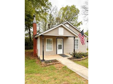 Charming single-story home with an American flag, inviting entrance and landscaped yard at 207 Morris St, Kings Mountain, NC 28086