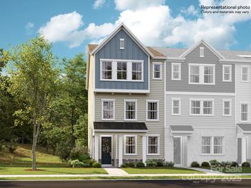 Charming three-story townhome with blue and beige accents, a black metal roof, and a well-manicured lawn at 4140 Skyboat Cir, Fort Mill, SC 29715