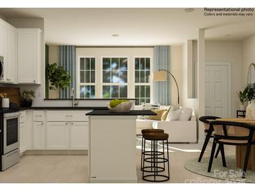 Modern kitchen featuring white cabinets, stainless steel appliances, an island with stool seating, and lots of natural light at 4539 Potters Wheel Dr, Fort Mill, SC 29715