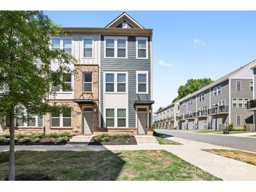 Beautiful townhome showcasing a well-manicured lawn, brick accents, and a modern facade at 5005 Sovereignty Ct, Charlotte, NC 28205