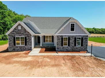 Charming single-story home with stone accents, gray siding, and a well-manicured yard at Tbd Boomer Ct # 10, Statesville, NC 28677