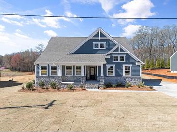 Charming home featuring a covered porch, stone accents, and eye-catching blue siding at Tbd Boomer Ct # 13, Statesville, NC 28677