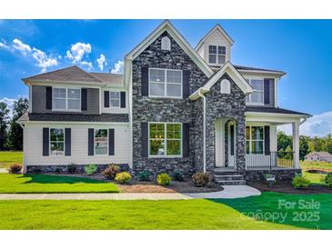 Charming two-story home with a stone facade, covered porch, manicured lawn, and beautiful architectural details at Tbd Boomer Ct # 9, Statesville, NC 28677