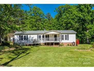 Well-maintained single-story home with charming front porch and wheelchair ramp access surrounded by lush trees at 1060 Sierra Rd, York, SC 29745