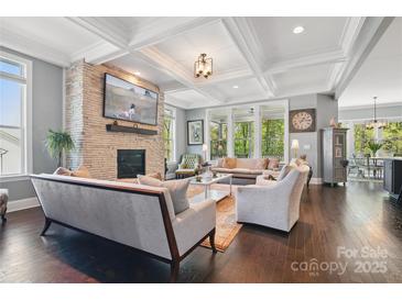Spacious living room featuring a stone fireplace, coffered ceilings, and an open floor plan at 164 Riverstone Dr, Davidson, NC 28036