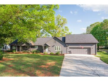 Charming single-story home with a well-manicured lawn, attached garage, and inviting front entrance at 235 Commodore Loop, Mooresville, NC 28117