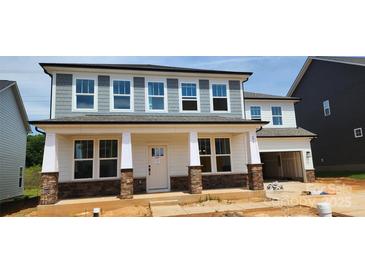 New two-story home with stone accents and covered front porch, enhancing curb appeal at 277 Supernova Dr # 12, York, SC 29745