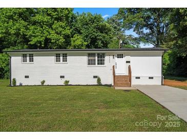 Charming single-story home features a fresh white paint, brick steps, and lush lawn at 3423 Archer Ave, Charlotte, NC 28217