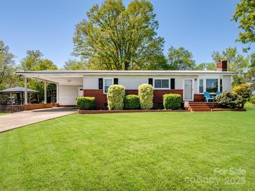 Charming single-story home features a lush green lawn, carport, and landscaped front at 7617 Pleasant Hill Church Rd, Marshville, NC 28103