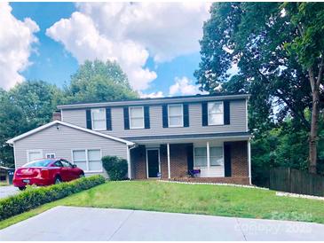 Charming two-story home with a well-maintained lawn, mature trees, and classic architectural details at 9404 Robert Burns Ct, Charlotte, NC 28213