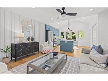 Bright living room featuring modern decor, wood floors, and blue kitchen accents at 1330 Dean St, Charlotte, NC 28216