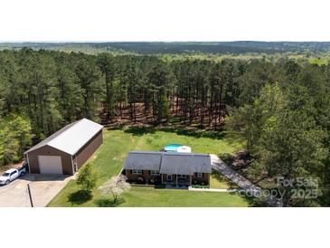 Aerial view of a home with a pool and barn surrounded by tall trees at 5381 Mount Carmel Rd, Heath Springs, SC 29058