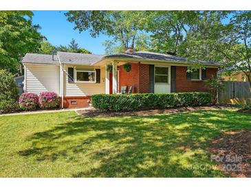 Charming brick home featuring a well-manicured lawn and lush landscaping at 576 Scaleybark Rd, Charlotte, NC 28209