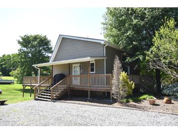 Charming home with a gravel driveway, inviting wooden deck and stairs, perfect for outdoor enjoyment at 5769 Birch St, Conover, NC 28613