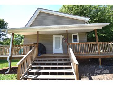 This home boasts a welcoming covered porch with wooden steps and railings, perfect for enjoying the outdoors at 5769 Birch St, Conover, NC 28613